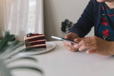 Kafede elinde cep telefonu olan bir kadın. dijital teknoloji iletişimi internet sosyal medya çevrimiçi kavramı.