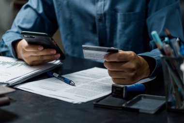 Kredi kartı tutan ve dizüstü bilgisayar kullanan eller. İnternetten alışveriş, internet bankacılığı. İş muhasebe finansal ve pazarlama kavramı.