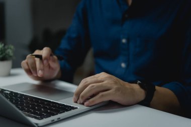 İşadamı masadaki dizüstü bilgisayarın klavyesinde el yazısı yazıyor. İş dünyası internet pazarlaması, çevrimiçi öğrenme ve finans kavramı.