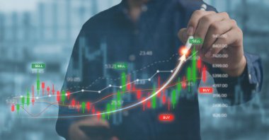 Sanal ekranda borsa analizini gösteren bir kalem tutan bir iş adamı. İş ve mali yatırım kavramı.