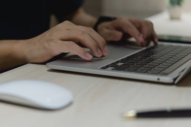 İnternette çalışan dizüstü bilgisayarı kullanan işadamı elleri, masadaki internet ve sosyal medyada bilgi teknolojisi verilerini araştırıyor.