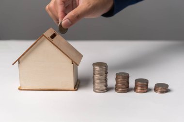 Model ev bankasına parlayan para koymak. Emlak konsepti için para biriktiriyorum. İşletme yönetimi finans konut kredileri veya ev satın almak için tasarruf.