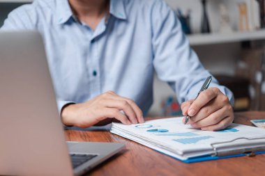 İş belgeleri veri raporu şeması ve grafik şeması dizüstü bilgisayarla birlikte. Finans evrak pazarlamada çalışan adam.