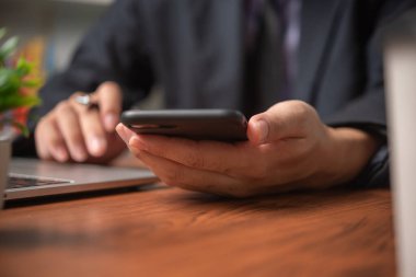 İş adamı cep telefonu yönetimi bilgilerini kullanıyor finansal belgeler, pazarlama çevrimiçi, iş ve ödeme dijital teknolojisi masasında.