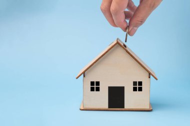 Domuz kumbarasına para yatıran adam ev için para biriktiriyor. Finansal planlama hedefleri, zenginlik yönetimi ve gayrimenkul. Biriktirme ve Yatırım İş Finans Konsepti.