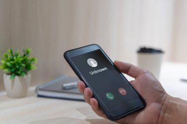 Bilinmeyen numaradan aranan bir adam var. Dolandırıcılık, dolandırıcılık ya da akıllı telefon konseptiyle dalavere. Gelen çağrıya cevap veren adam.