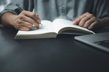 Ofisteki deftere kalem yazan erkek elleri. Öğrenme, eğitim ve çalışma. Hedefler, planlar, yapılacaklar ve dilekler listesi..