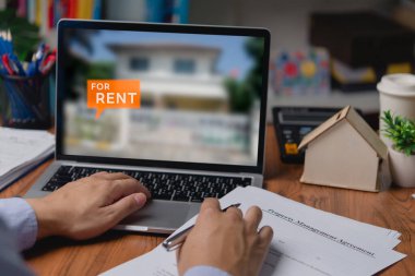 Emlak kiralama evi ya da internet üzerinden konut aramak için dizüstü bilgisayar kullanan bir adam