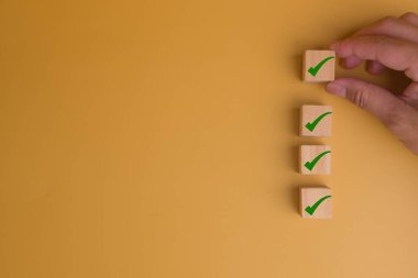 İnsan eli İşaretleme simgesiyle küp tahtasını kopyalama alanı denetleme kavramına sahip sarı arkaplan üzerine yerleştiriyor.