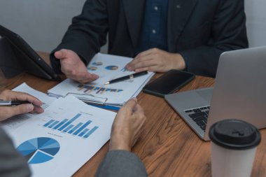 İş adamları Toplanma Ekibi ve yeni başlangıç gelir tabloları ve dizüstü bilgisayarla grafikler üzerinde çalışan yatırımcıları analiz etmeyi planlıyorlar. İş analizi ve strateji kavramı.