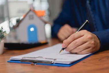 İş adamı, iş ve finans için sözleşme hukuku ve kağıt işleri yazıyor, belge yazıyor, iş başvurusu formlarını tamamlıyor, emlak ve sigorta kavramını geliştiriyor..