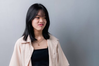 Genç ve güzel Asyalı genç kız üzgün ve hayal kırıklığına uğramış bir yüz ifadesi sergiliyor..