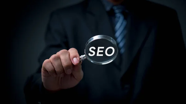 SEO Search Engine Optimization Strategy for Improved Web Traffic, Ranking and Sales Digital Marketing concept. Business Growth and Online Marketing.man holding through magnifying glass.
