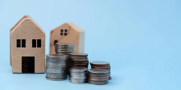 Stacking coins houses model.Saving money and financial investment to buy house future.Concept real estate, property mortgage taxes and revenue residential.