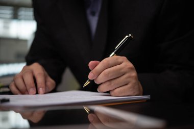 Adam kalem yazma evraklarıyla el ele veriyor. Yatırım için vergi ve finansman planlıyor. 