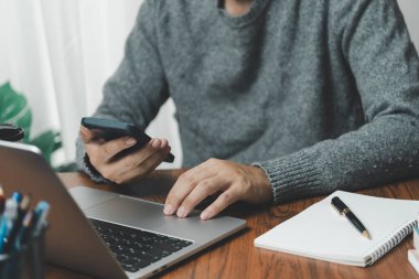 Çalışma masasında cep telefonu ve dizüstü bilgisayar kullanan iş adamı dijital internet ağı sosyal medya ve veri iletişimi.