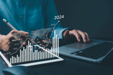 Finansal tablolar ve grafik analizleri artan gelirleri gösteriyor. 2024 yılında dijital ekran tabletinin üzerinde yüzen, büyüme ve başarı stratejisi ile ilgili iş dünyası.