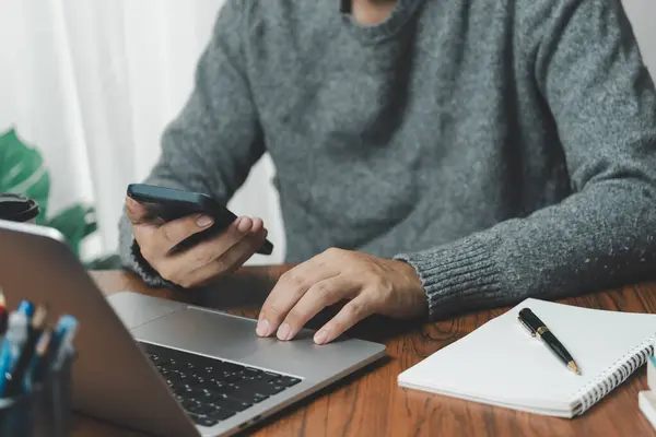 Çalışma masasında cep telefonu ve dizüstü bilgisayar kullanan iş adamı dijital internet ağı sosyal medya ve veri iletişimi.