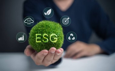 Üzerinde ESG harfleri olan yeşil bir top tutan biri var. Sürdürülebilirlik ve çevre sorumluluğu kavramı