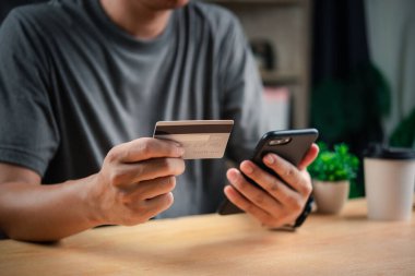 Akıllı telefondan kredi kartı bilgilerini doğrulayan adam siber güvenliği vurguluyor..