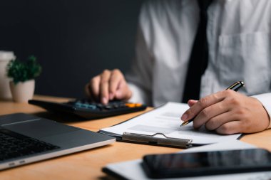 Belgeler üzerindeki bütçe hesap makinesi ile hesaplanıyor, mali planlama eylemde.