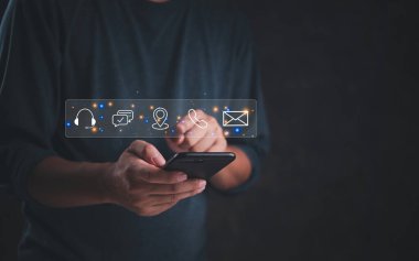 İletişim simgelerine sahip akıllı telefon kullanan kişi, iş pazarlama çevrimiçi olarak bizimle bağlantı kurar ve müşteri hizmetleriyle iletişime geçer. dijital teknoloji istemciye internet yardımı