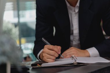 Not defterinde kalem listesi ve çizelgesi olan bir işadamı. Günlük günlüğü veya hedef ve not defteri iş konsepti.