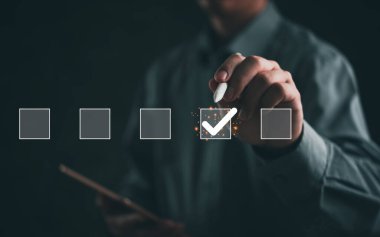 İş adamının eli dijital arayüzde işaretleme kutusunu işaretliyor. Karar verme ve görev yönetimini gösteriyor. İş planlama, değerlendirme ve araştırma konuları için ideal. Modern, profesyonel tarz..