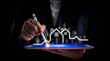 İşadamı, dijital tablette emlak piyasasının büyümesini inceliyor. Mülk yatırımını, konut piyasası analizini, finansal planlamayı temsil ediyor. Gayrimenkul ve ekonomik strateji görselleri için ideal.