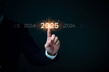 Bir el 2025 yılını seçer, hedef belirleme, iş vizyonu ve stratejik planlamayı sembolize eder. İş tahminleri, şirket hedefleri ve gelecekteki planlar için harika..