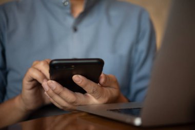 İş adamı, sosyal ağlar ve e-posta metinleri için bilgisayarlı cep telefonu kullanıyor.