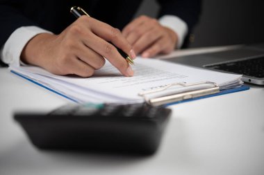 İş anlaşması, işadamı kontrolü ve imzası bir belge, profesyonel masa, ofis ekipmanları, hesaplama giderleri, modern işletme, finans ve hukuk