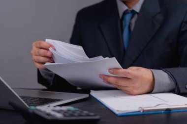İşletme yöneticisi mali verileri ve resmi belgeleri kontrol ediyor. İş analizi, finans planlaması, yönetim, vergi hesaplaması ve profesyonel muhasebe işi.