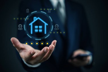 Daha iyi emlak kararları için akıllı telefon ve yıldız reytingleri ve konum işaretleyicileri de dahil olmak üzere dijital simgeler kullanarak mülkü analiz eden kişi.