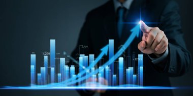 İşadamı dijital bir grafik ve okları işaret ederek yükselen bir eğilim, iş büyümesi, veri analizi ve finansal yatırımların performansını gösteriyor. istatistikler, pazar eğilimleri gelişimi
