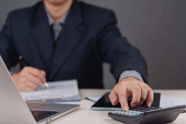 İş adamı hesap makinesi kullanıyor ve finansal belgeleri inceliyor. muhasebe, mali analiz, bütçe planlaması ve işletme vergisi, finans yönetimi ve strateji yatırım planlama.