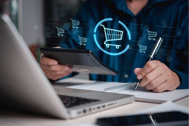İş dünyası profesyoneli alışveriş arabası verilerini analiz ediyor, e-ticaret operasyonlarını, çevrimiçi satışları ve tüketici satın alma davranışlarını temsil ediyor.