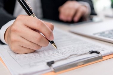 İş ve mali evraklar doğrulaması, yakın plan bir sözleşme üzerinde çalışıyor. Şirket, yatırım ve hukuki danışmanlık için ideal..