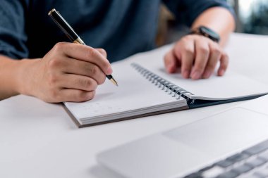 Kalem ve dizüstü bilgisayarlı el yazısı, eğitim kavramı, çevrimiçi öğrenme, planlama, üretkenlik ve kişisel gelişim.