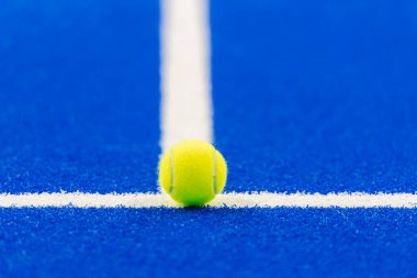 Raket tenis ve tenis topu. Mavi kortta beyaz çizgiler var. Yatay spor posteri, tebrik kartları, başlıklar, web sitesi