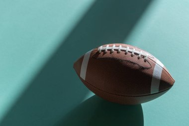 American football leather ball on mint color background. Top view. Game equipment horizontal sport theme poster, greeting cards, headers, website and app
