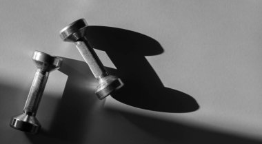 Kır arka plandaki dambılları kapatın. Spor ve spor malzemeleri. Yatay spor posteri, tebrik kartları, başlıklar, web sitesi.