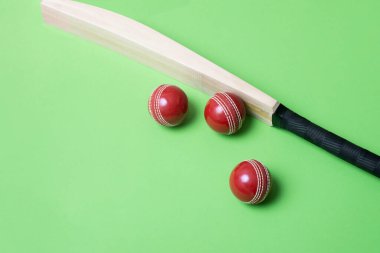 Yeşil arka planda kriket sopası ve kırmızı toplar. Yatay spor temalı poster, tebrik kartları, başlıklar, web sitesi ve uygulama