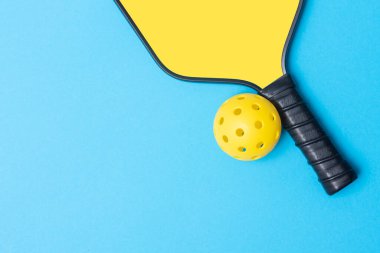 Yellow pickleball racket and ball on blue background. Horizontal education and sport poster, greeting cards, headers, websit clipart