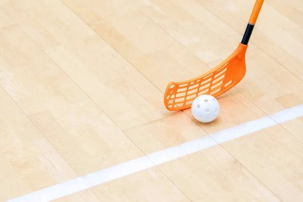 Floorball stick and white ball on hardwood court floor. Horizontal sport theme poster, greeting cards, headers, website and app