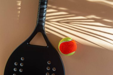 Bej arka planda siyah profesyonel plaj tenis raketi ve top. Yatay spor temalı poster, tebrik kartları, başlıklar, web sitesi ve uygulama
