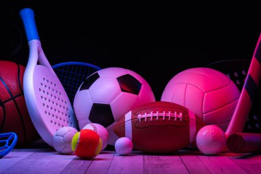Spor aletleri, raketler ve toplar parke kort zemininde, neon ışıklı arka planda. Yatay eğitim ve spor afişi, tebrik kartları, başlıklar, websitesi