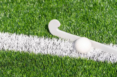 Çim hokeyi sopası ve top yeşil çimlerde. Takım sporu konsepti. Yatay spor temalı poster, tebrik kartları, başlıklar, web sitesi ve uygulama