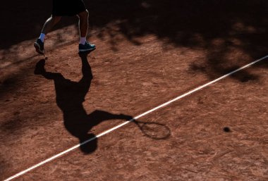 Tenisçinin gölgesi kil tenis kortunda. Yatay spor temalı poster, tebrik kartları, başlıklar, web sitesi ve uygulama