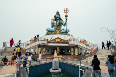 Pokhara, Nepal - 15 Nisan 2023: Gandaki 'nin Kaski ilçesi Pokhara yakınlarındaki tepe istasyonunda Pumdikot Shiva Heykeli' ni ziyaret eden turistler ve yerel halk.